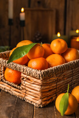 Basket with ripe tangerines on wooden table, closeup