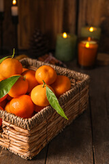 Basket with ripe tangerines on wooden table, closeup