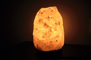 Salt lamp on the table in the room glows in the night