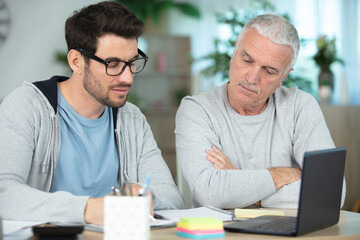 adult father and son discuss acount and financial