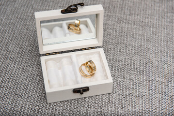 gold wedding rings in a white box with a mirror