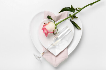 Table setting for Valentine's Day with rose on white background