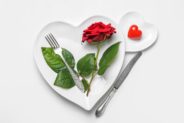 Table setting for Valentine's Day with red rose on white background