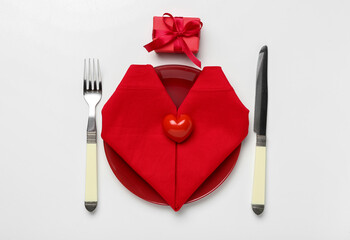 Table setting for Valentine's Day with gift on white background