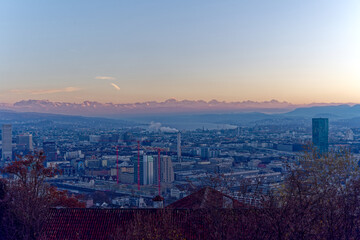 Aerial view over City of Zürich with Limmat River and Swiss Alps in the background on a sunny autumn evening. Photo taken December 6th, 2022, Zurich, Switzerland.