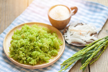 Thai dessert - pounded unripe rice food rice flakes cereal with coconut and sugar, Green rice sweet with ears of rice pandan leaf, Food dessert or snacks - Khao Mao name in Thailand