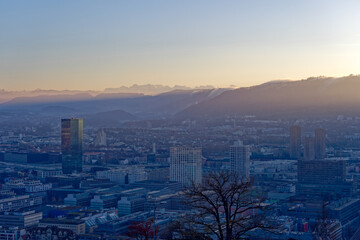 Aerial view over City of Zürich with skyscrapers and Swiss Alps in the background on a sunny autumn evening. Photo taken December 6th, 2022, Zurich, Switzerland.