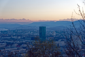 Aerial view over City of Zürich with skyscraper Prime Tower and Swiss Alps in the background on a sunny autumn evening. Photo taken December 6th, 2022, Zurich, Switzerland.