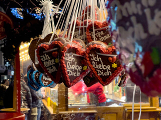 Gingerbread hearts with German text I love you at a Christmas market hut.  In the evening at the Christmas market in Paderborn, Germany.