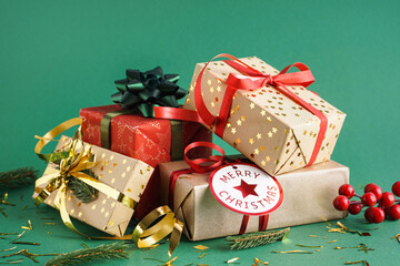 Christmas gifts with fir branches and confetti on green background