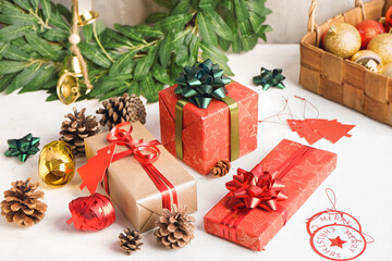Christmas gifts with fir cones on white table