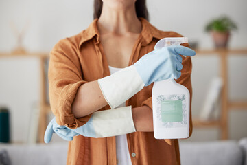 Woman, spring cleaning and spray bottle with arms crossed for housekeeping, sanitation or...