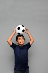 Hispanic Latino 8-year-old boy plays with a soccer ball very excited that he is going to see the football game and wants to see his team win © Arlette