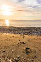 beautiful sea sunrise on a rocky sea coast with calm water , amazing cloudy sky and reflection on water surface