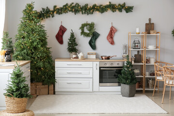 Interior of kitchen with Christmas trees, white counters and socks