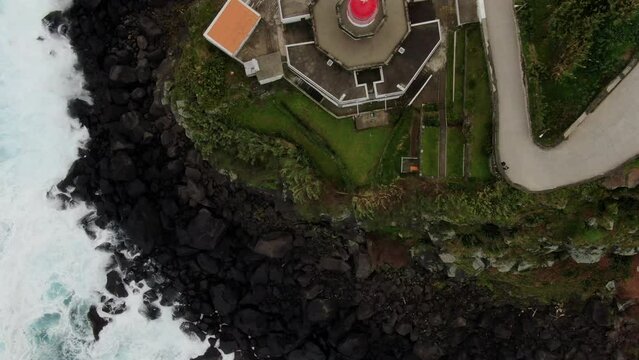 Wonderful overhead aerial shot over the Arnel lighthouse on the Portuguese island of S&atilde;o Miguel in the Azores. It is observed how the waves break against the coast.
