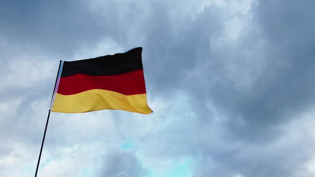 Real german flag waving in cloudy day sky