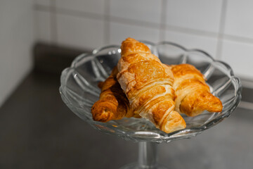 croissants are in a crystal dessert vase in the kitchen. homemade cakes. selective focus