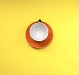 Obraz na płótnie Canvas Orange mug with coffee isolated on a yellow background