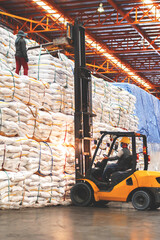 Fototapeta na wymiar Vertical view of forklift lift jumbo bag of sugar stacking inside a warehouse. Food logistics. 