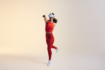 Fototapeta na wymiar Happy young woman having fun in a virtual reality fitness game