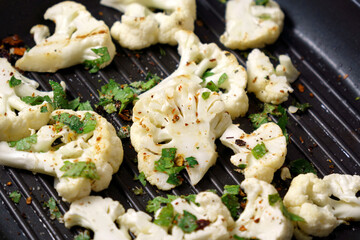Cauliflower steaks cooking. Healthy eating, plant based meat substitute concept.