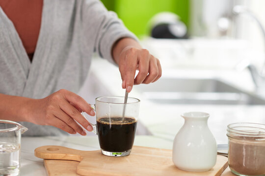 Woman Mixing Sugar In Coffee