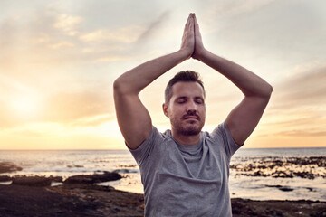 Sunrise yoga, peace and man at the beach for mind wellness, spiritual freedom and relax exercise by the ocean in Bali. Zen meditation, soul training and person at the sea for calm in the morning