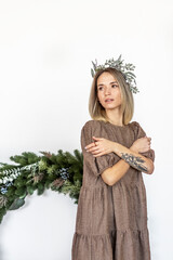 A young woman with blonde hair with a Christmas wreath. New Year's concept,Christmas decorations.