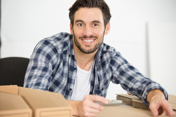 Fototapeta premium handsome man working in manufacture with boxes