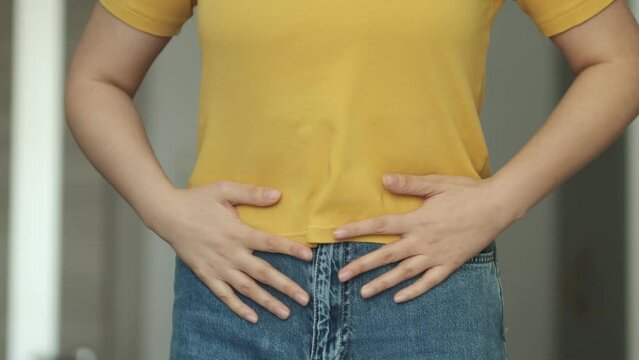 Woman touching his stomach. Stomach pain and others stomach disease concept.Girl having a stomachache. Young woman suffering from abdominal pain. Woman Stomach Ache.