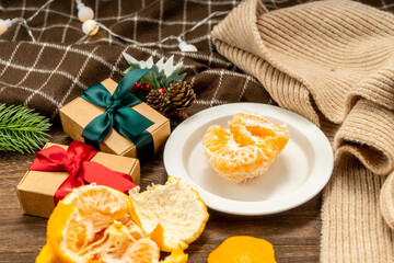 christmas concept with Tangerines, presents, Fir, scarf, lights, on wooden background