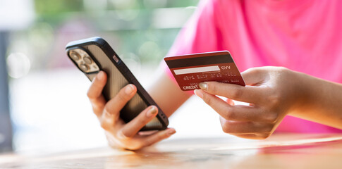 online payment Asian woman hands holding credit card and using smartphone for online shopping.