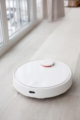 the robot vacuum cleaner mops the floor leaving the clean behind, smart home - obrazy, fototapety, plakaty