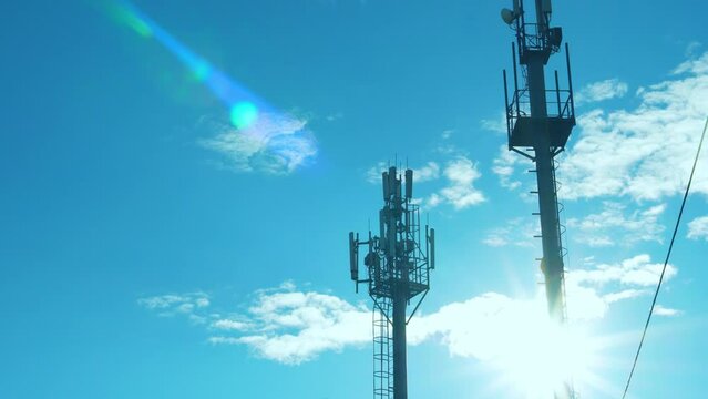Cellular Communication Stations, Cell Towers in the Rays of the Sun on a Sunny Day Blue Sky White Clouds Time Lapse.