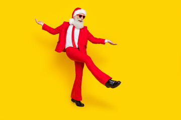 Fototapeta na wymiar Full length photo of good mood retired guy wear red tux claus hat dancing empty space isolated yellow color background