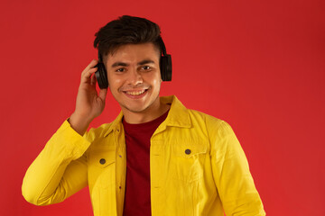 Portrait of a happy young man listening music on headphones