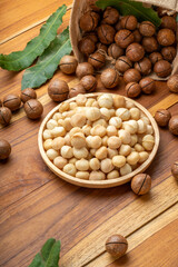 Roasted Macadamia nut in wooden plate on wooden background, Macadamia nuts on wooden background.