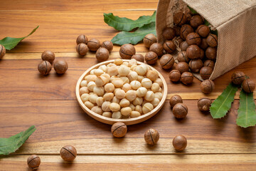 Macadamia nut in wooden plate on wooden background, Roasted Macadamia nuts on wooden background.