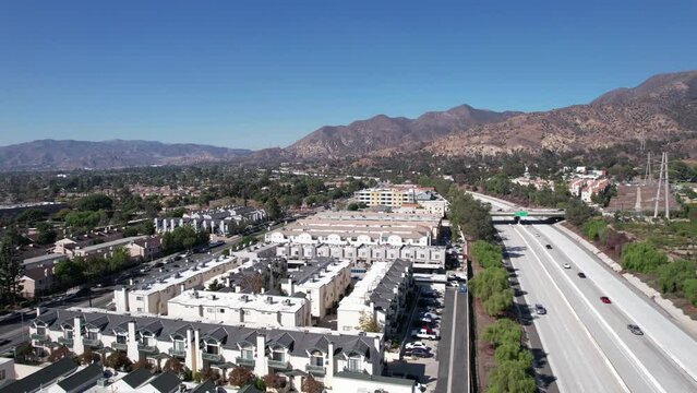Aerial View, Traffic on American Interstate 210 Highway and Sylmar Neighborhood of Los Angeles, San Fernando Valley. California  USA, Panoramic Drone Shot