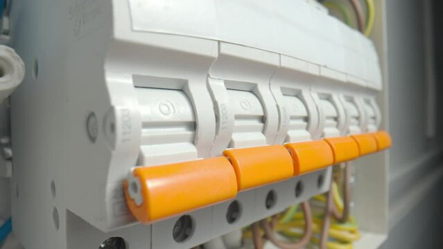 Circuit breaker switching. Close up of finger switching off high voltage electric power line. Power supply switches in electric fuse box. Electricity box switch. Turning off electric energy power.