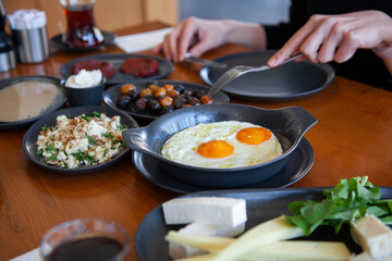 Turkish breakfast table. Pastries, vegetables, greens, olives, cheeses, omelette, spices, jams, tea in a thermos, large composition. Breakfast concept in restaurant and cafe.