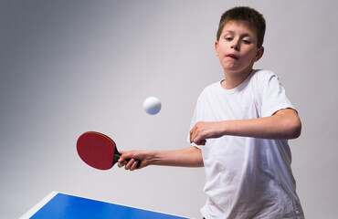 Teenager play  table tennis in on white background - obrazy, fototapety, plakaty