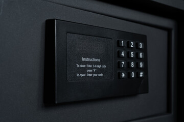 Black steel safe box with electronic security lock. Modern safety locker in a hotel room or at home.