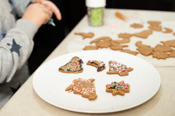 The boy's hands make Christmas cookies. The little cook.