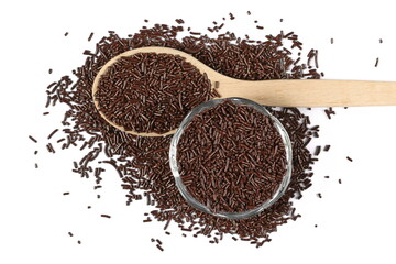 Chocolate sprinkles, granules in wooden spoon and glass bowl isolated on white, top view 