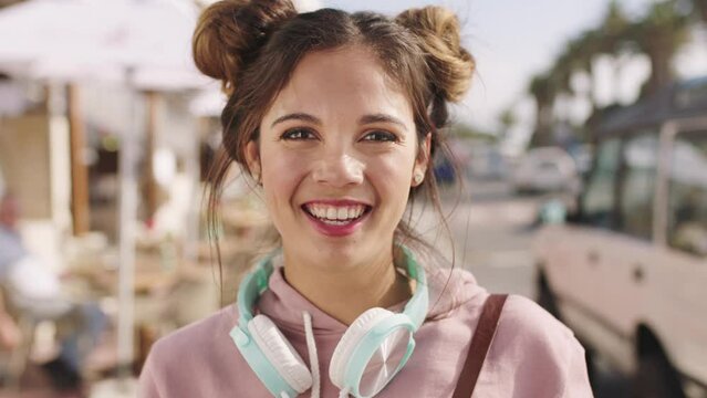 Happy, music and face of woman in city street for relax journey while listening to wellness podcast, radio sound or audio song. Headphones, smile and portrait of girl walking in Miami Florida street