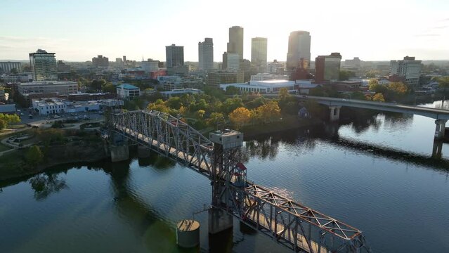 Little Rock Arkansas. Aerial of AR River and bridges with skyline in autumn sunset. Warm golden hour light. Establishing shot.