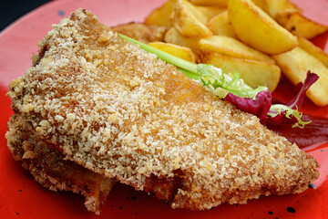 Pork schnitzel with potatoes, sauce and herbs