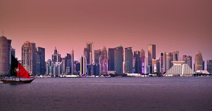 Traditional boat sail with Portugal country flag design for World Cup 2022 in Corniche area with amazing sunset view of cityscape skyscraper buildings